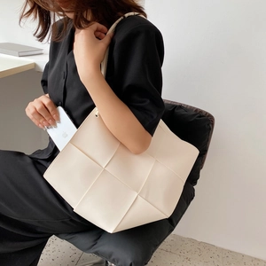 Minimalist white wide weave leather tote bag with a spacious interior and shoulder strap