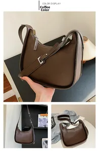 Detail of dark brown leather texture and adjustable strap on the vintage baguette bag