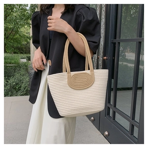 Detail of hand-woven tote bag showing cream and khaki bicolor mesh texture and wide straps