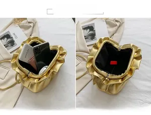 Macro view of gold metallic cloud clutch showing large interior capacity for essentials