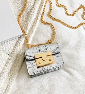 Detail view of silver crocodile pattern mini chain bag with elegant gold metallic lock