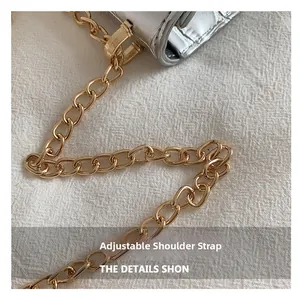 Detail of silver metallic handbag with gold chain strap and adjustable shoulder strap