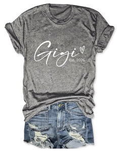Détail du t-shirt gris Gigi Est. 2026 avec imprimé coeur et short en jean usé
