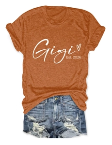 T-shirt orange Gigi Est. 2026 et short en jean déchiré posés sur fond blanc neutre