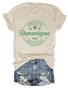 Flat lay of beige crew neck t-shirt with shamrock print and blue ripped denim shorts