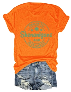 Detail of orange St. Patrick's Day T-shirt with shamrock print and distressed denim shorts