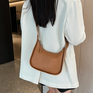 Minimalist caramel brown leather hobo shoulder bag styled with a white blazer outfit