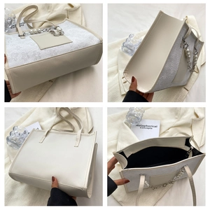 Detail of floral lace embroidery and pearl chain handle on off-white tote bag
