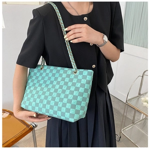 Close-up of mint green checkered tote bag showing unique wrinkled texture and gold chain