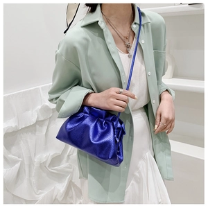 Dettaglio della borsa nuvola blu metallizzato con coulisse e tracolla sottile su modella