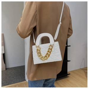 Détail du sac matelassé blanc avec chaîne dorée et style élégant en bandoulière porté