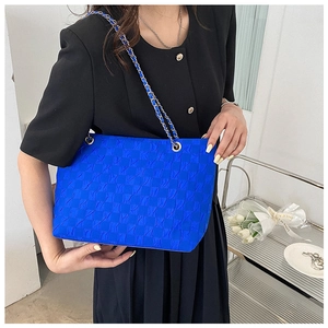 Close-up of klein blue checkered tote bag with gold and blue metal chain strap