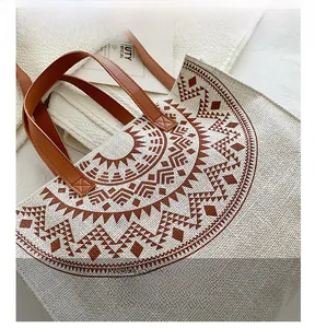 Close-up of canvas tote bag showing radial geometric print and brown leather handle
