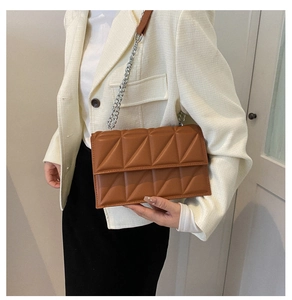 Brown quilted leather chain bag styled with white blazer and black dress for women