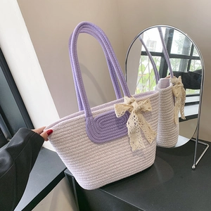 Handwoven purple and white cotton tote bag with lace bow on a dresser tabletop