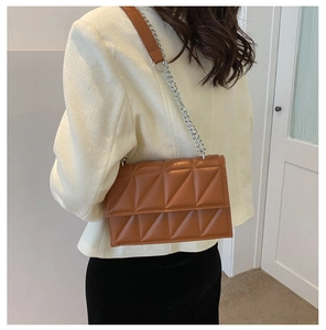 Detailed view of brown geometric quilted PU leather crossbody bag with silver chain strap