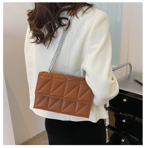 Brown quilted chain bag side view showing triangular stitching texture and leather strap