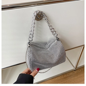 Détail d'un sac à bandoulière argenté serti de strass avec poignée en chaîne métallique