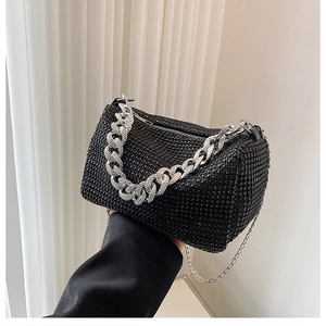 Détail du sac cylindrique à strass noirs avec chaîne argentée et bandoulière en métal