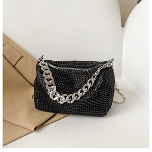 Détail d'un sac de soirée noir orné de strass avec une grosse chaîne argentée
