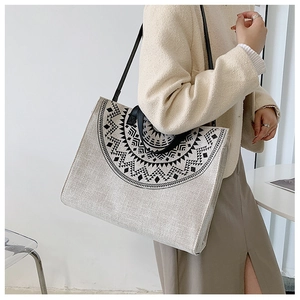 Close-up of geometric pattern on a canvas tote bag with black leather straps