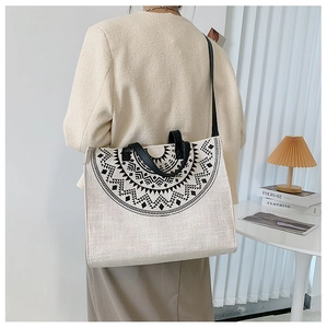 Detailed view of canvas tote bag featuring geometric print and leather handles