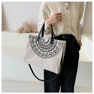 Detail of canvas tote bag with black geometric ethnic pattern and adjustable shoulder strap