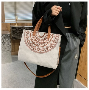 Detail of bohemian canvas tote with ethnic mandala pattern and brown leather straps