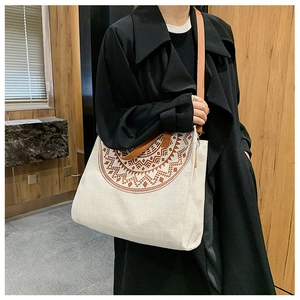 Detail of bohemian canvas tote bag with brown geometric pattern and leather straps
