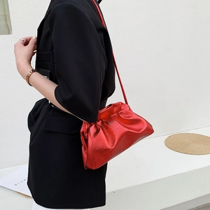 Borsa a nuvola rossa metallizzata con tracolla e texture martellata indossata dal modello
