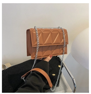 Detail of caramel brown quilted chain bag featuring geometric stitching and silver hardware