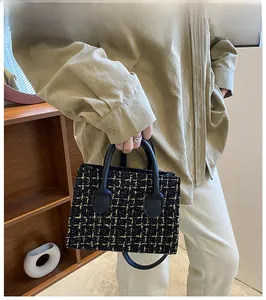 Fashionable tweed handbag with black gold texture shown on model in a soft indoor setting