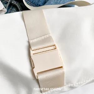 Dettaglio della borsa a tracolla in nylon bianco con fibbia minimalista e cinturino
