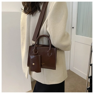 Detail of dark brown square crossbody bag with wide strap and detachable coin purse pouch