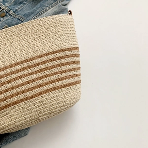 Close-up of the horizontal stripe pattern and woven texture on a summer straw bag
