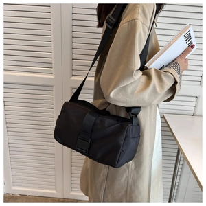 Dettaglio della borsa a tracolla in nylon nero con fibbia e cinturino regolabile