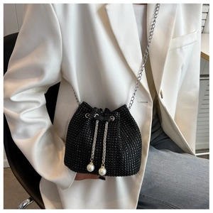 Detail van zwarte strass-emmerstas met zilveren ketting en parel trekkoord