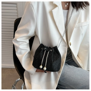 Detail van zwarte strass emmertas met zilveren ketting en witte parel trekkoorden