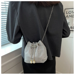 Detail van zilveren strass emmertas met parelkoord op een crossbody-model