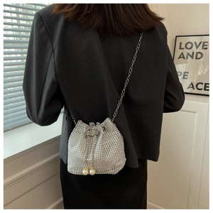 Detail van zilveren bucket bag met strass steentjes en elegante parel trekkoorden