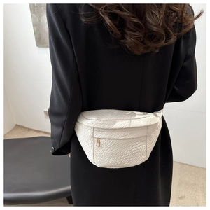 Detail of white woven texture waist bag with gold zipper shown on model's waist