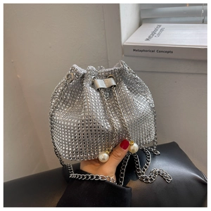 Detail van zilveren bucket bag met strassteentjes, kettingband en parelkoord
