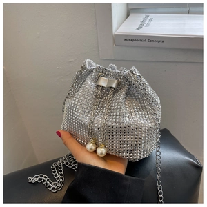 Detail van zilveren strass emmertas met parelkoord en metalen kettingriem