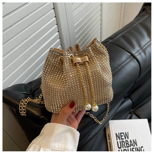 Detail van champagne strass emmertas met gouden ketting en parel trekkoord