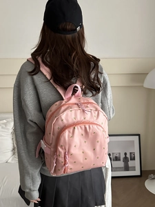 Pink floral print backpack with waterproof nylon material shown on a model