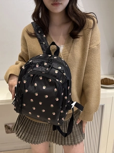 Mini black nylon backpack with pink floral embroidery and a minimalist aesthetic style