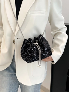 Detail of black sequin drawstring bucket bag with pearl accents and metal chain strap