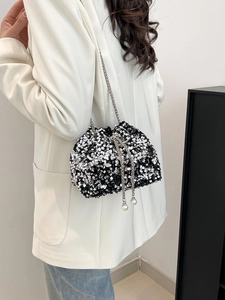 Detail of sequin bucket bag featuring pearl drawstring and silver chain strap for women
