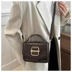 Detail of dark brown vintage crossbody bag with matte leather finish and metal clasp