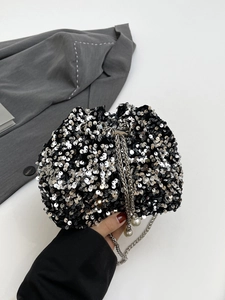 Detail of sequin bucket bag with silver chain strap and decorative pearl drawstrings